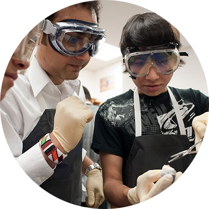 Teaching fellow and students conducting science experiment together at Knowles Teacher Initiative